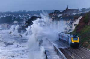 Intercity train leaving Dawlish station and getting a soaking from storm waves